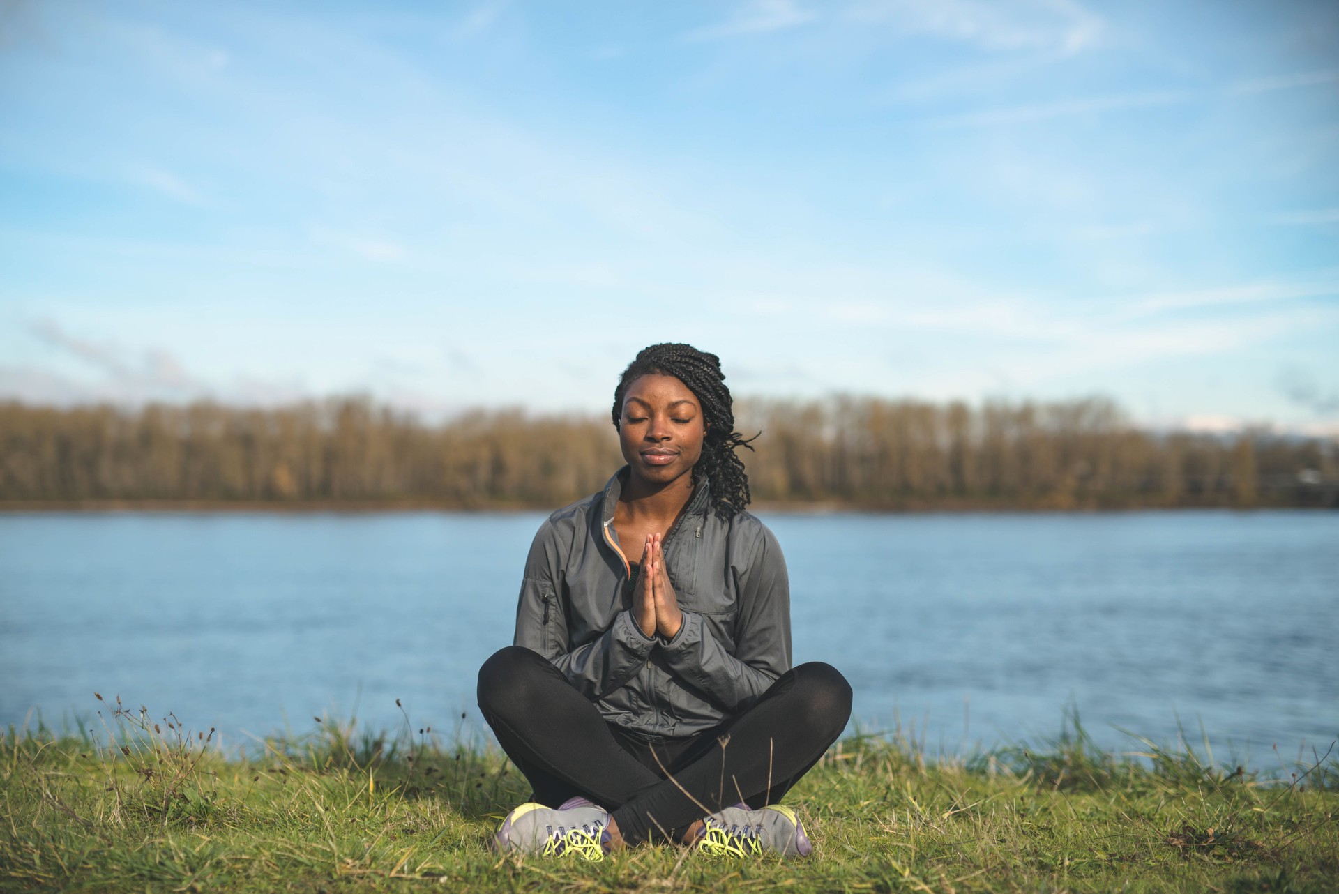 Ethnic adult female practicing meditation outdoors in nature