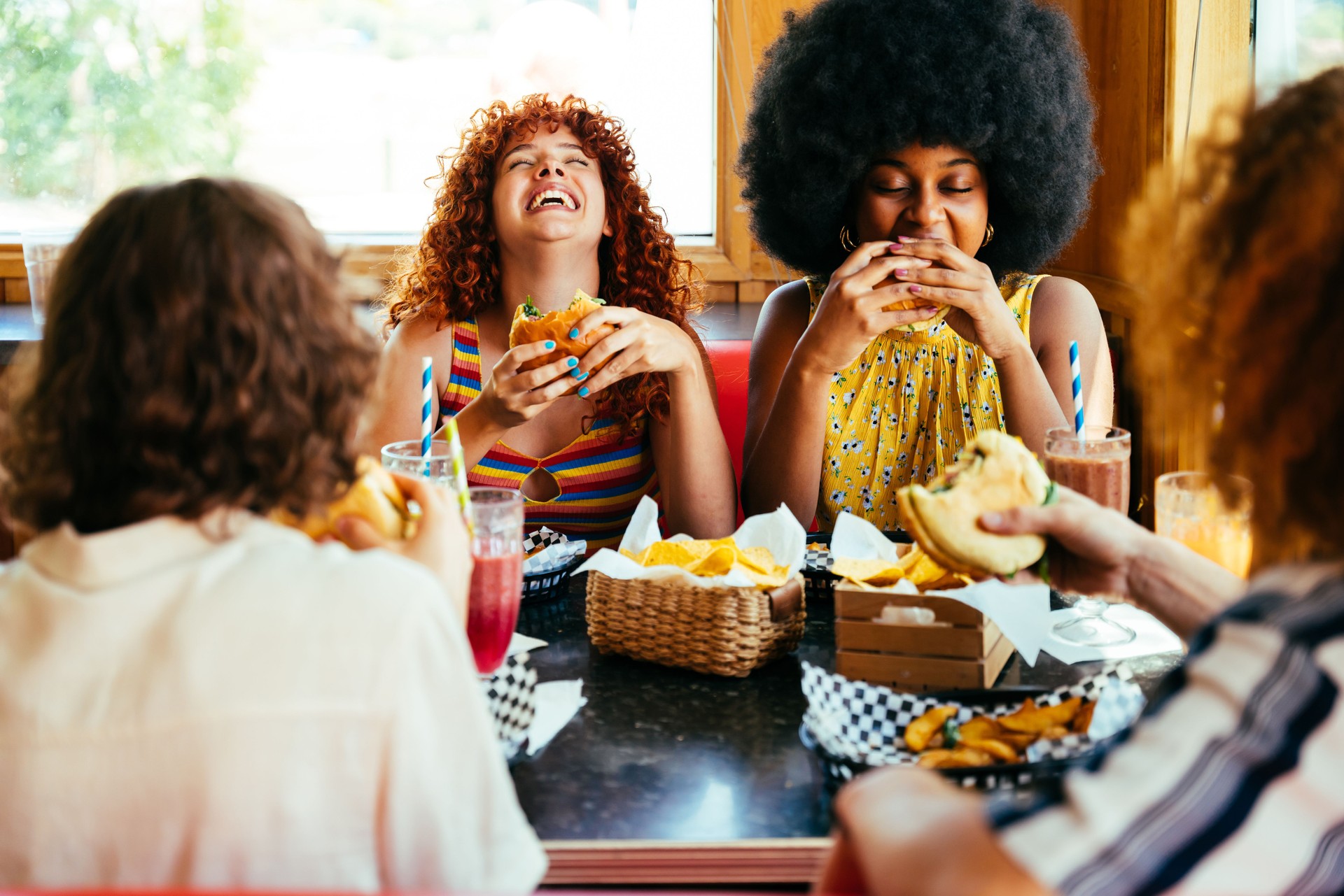 Multiethnic group of friends having meal at diner restaurant